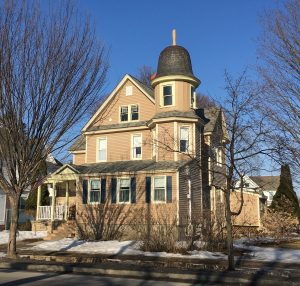 tan house with bell shaped tower roof