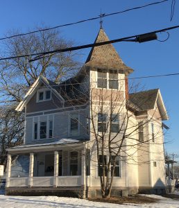cream and tan house with a 3-story tower